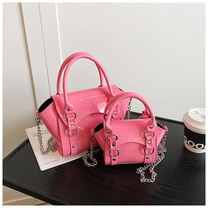 Macro detail of two pink patent leather handbags with silver chain and glossy finish