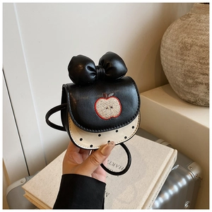 Détail du mini sac bandoulière pomme avec décoration nœud et couture en tissu à pois