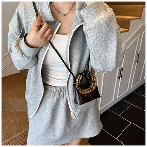 Detail of grey knitted tracksuit showing soft texture and zip-up hooded jacket with skirt