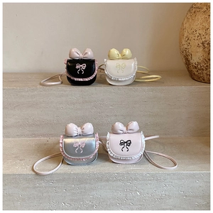 Detailed view of kids' bow crossbody bags in black, beige, silver, and pink with lace trim
