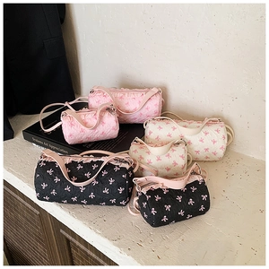 Detail of a textured cylinder bag featuring pink bow patterns and ruffle trim edges