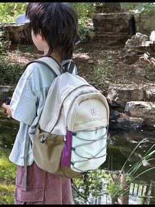 Outdoor shot of a colorful patchwork kids backpack with bungee cords and side pocket