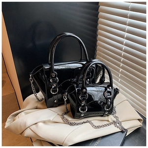 Detailed set of black patent leather chain bags with glossy finish and silver metal rings