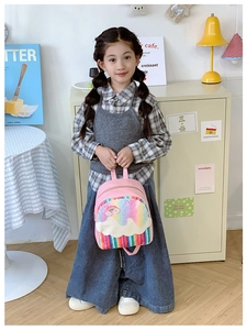 Detail of cute pink kids backpack featuring rainbow sequins and white cloud design