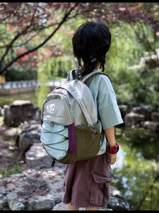 Outdoor shot of lightweight multi-color kids backpack with elastic cords and drawstring side pockets