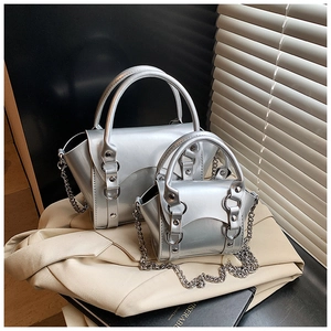 Close-up of silver metallic mini handbags with mirror finish and stylish chain straps