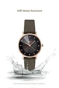 Dettaglio impermeabile dell'elegante orologio da donna oro rosa con quadrante nero e pelle