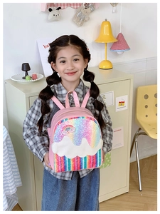 Detail view of pink sequin kids backpack with rainbow stripes and cloud pattern design