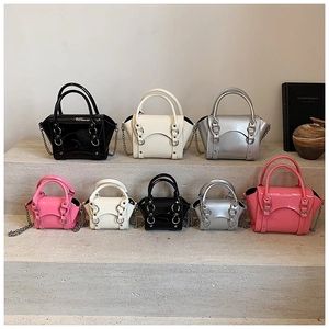 Detail shot of mini patent leather handbags in multiple colors with metallic chain straps