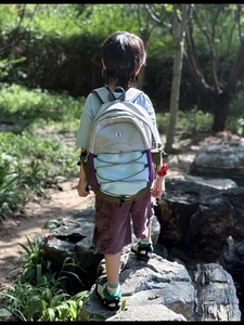 Detail view of colorful patchwork kid backpack with elastic cords and mesh side pocket