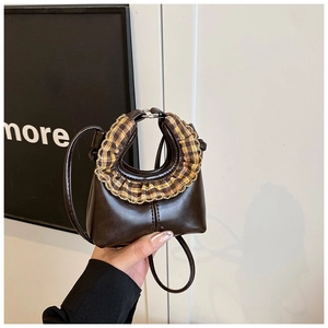 Detail of mini dark brown crossbody bag featuring yellow plaid ruffle trim and leather texture