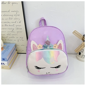 Close-up of glittery rainbow unicorn detail and eyelashes on a purple kids backpack