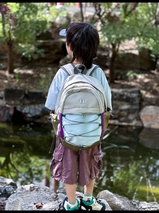 Kids colorful outdoor backpack with adjustable straps and flower patch in garden setting