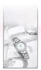 Detailed view of silver steel watch with white rhinestone dial near a glass