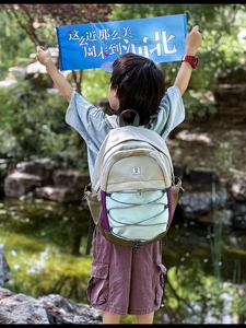 Outdoor shot of lightweight multi-color patchwork backpack with elastic bungee cords