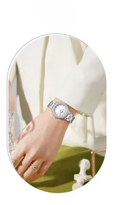 Close-up of minimalist silver stainless steel watch with rhinestone bezel on a model's wrist