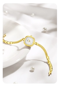 Détail macro d'une montre dorée élégante avec index en cristal sur fond de soie