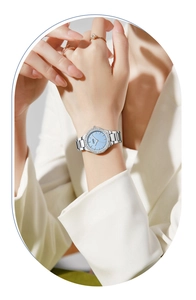 Detail of silver steel watch featuring light blue rhinestone dial on female wrist