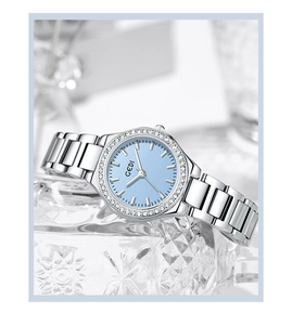 Macro detail of silver quartz watch featuring light blue dial and rhinestone-encrusted bezel