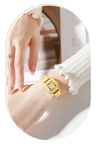 Elegant gold square quartz watch with Roman numerals on female wrist with white sleeve