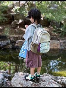 Detail of multi-color outdoor kids backpack with elastic cords and side water bottle pocket