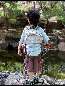 Outdoor view of lightweight children's backpack with bungee cord system and water bottle pockets