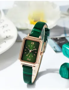 Detail einer eleganten rechteckigen Roségold-Uhr mit grünem Zifferblatt und Lederband