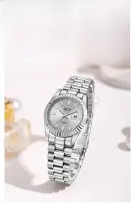 Détail d'une montre à quartz argentée avec lunette cannelée et affichage de la date