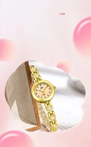 Gros plan d'une montre à quartz dorée avec bracelet serti de cristaux et cadran champagne