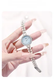 Gros plan d'une montre bracelet en perles avec cadran bleu et lunette en strass chic