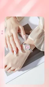 Gros plan d'une montre élégante à cadran rose avec bracelet à strass argentés au poignet