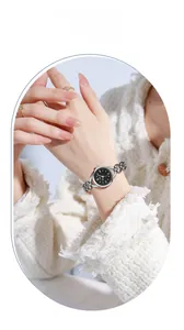Close-up of a ladies' silver chain watch with a black dial and Roman numerals on a wrist