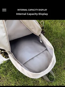 Internal capacity display of a lightweight school backpack on a natural grass background