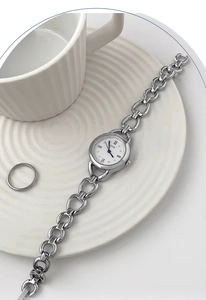 Detailed close-up of a silver GEDI watch bracelet set elegantly on a white textured plate
