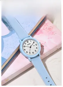 Detail view of light blue quartz watch with round white dial and date display window