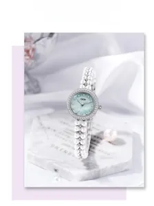 Détail d'une montre bracelet double rang de perles avec lunette en cristal sur marbre