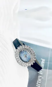 Détail d'une montre à quartz pour femme avec lunette tournesol en strass et cadran bleu