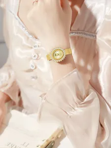 Close-up of GEDI vintage gold quartz watch with rhinestone bezel on a model's wrist