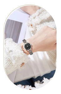 Detail of silver link bracelet watch with black dial worn on wrist for an elegant look