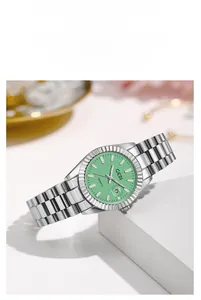 Détail d'une montre à quartz avec cadran vert, lunette cannelée et guichet de date