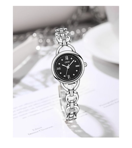 Detail of silver chain strap and black dial GEDI quartz watch for women shown with props
