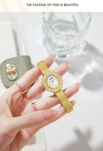 Detail of luxury gold wheat-ear watch with crystal bezel and woven metal strap