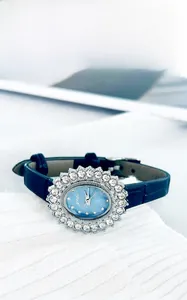 Gros plan d'une montre de luxe pour femme avec lunette en strass et cadran bleu texturé