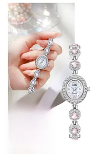 Macro shot of oval mother-of-pearl watch dial with elegant pink gemstone link bracelet