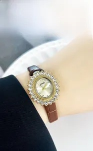 Montre pour femme avec cadran doré rayons de soleil, lunette en cristal et bracelet brun
