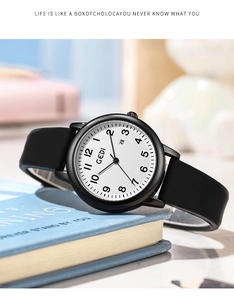 Macro detail of GEDI minimalist quartz watch with black silicone strap on a book
