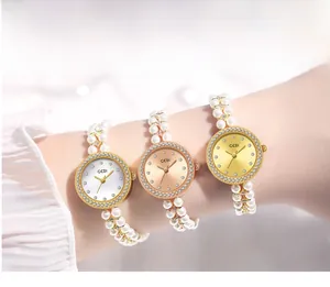 Détail d'une montre femme avec bracelet en perles et lunette sertie de diamants brillants