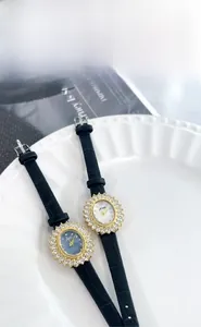 Détail de montres de luxe à cadran ovale avec lunette en cristal et bracelet en cuir noir