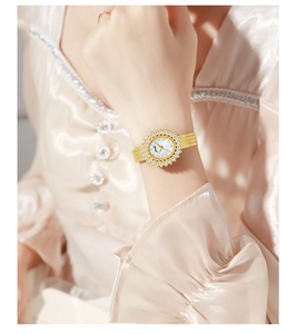 Detail of elegant gold woven strap and shimmering zircon sunflower bezel on women's watch