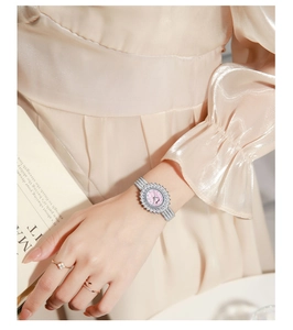 Detail of a pink sunray dial watch with crystal petals and silver Milanese band